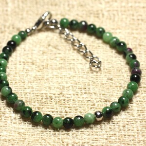 Peut inclure: Un bracelet de perles composé de petites pierres précieuses rondes vertes et noires avec des touches de rouge. Le bracelet est doté d'un fermoir et d'une chaîne réglable de couleur argentée. Les perles sont enfilées pour former un cercle complet.