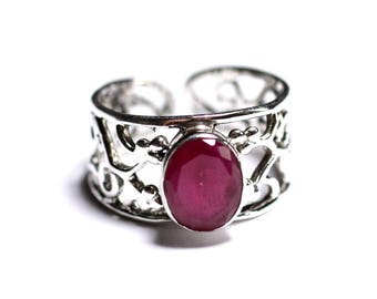 May include: A silver ring with an intricate filigree design and a large oval-shaped ruby gemstone.