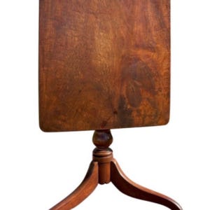 May include: A rectangular wooden side table with a dark brown finish. The table has a pedestal base with three curved legs. The tabletop is approximately 24 inches wide and 30 inches tall.