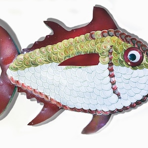 May include: A red and white fish sculpture made from bottle caps. The fish has a large eye and a red mouth. The bottle caps are arranged in a pattern to resemble scales.