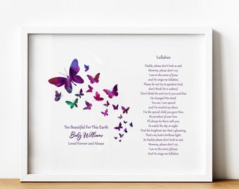 May include: A white framed print with a poem about a baby who has passed away. The poem is titled "Lullabies" and includes the text "Too Beautiful For This Earth Baby Williams Loved Forever and Always". The print features a design of purple and green butterflies flying upwards.
