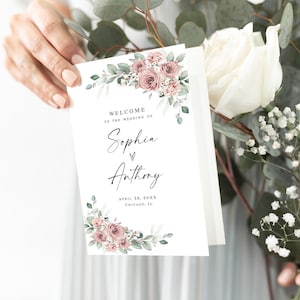 May include: A white wedding programme with a floral design featuring pink roses and green leaves. The text reads "Welcome to the wedding of Sophia & Anthony, April 26, 20XX, Chicago, IL."
