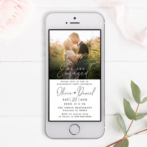May include: A smartphone screen displaying a digital save-the-date announcement for an engagement party. The announcement features a photo of a couple embracing in a field, with the text "We are Engaged" in a cursive font. The announcement includes the couple's names, Olivia and Daniel, the date and time of the party, and the location: The Virtue Restaurant in Chicago, Illinois.