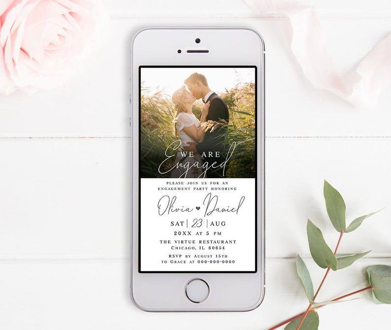 May include: A smartphone screen displaying a digital save-the-date announcement for an engagement party. The announcement features a photo of a couple embracing in a field, with the text "We are Engaged" in a cursive font. The announcement includes the couple's names, Olivia and Daniel, the date and time of the party, and the location: The Virtue Restaurant in Chicago, Illinois.