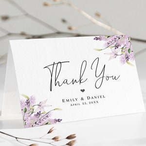 May include: A white thank you card with a purple floral design and the text "Thank You" in black script. Below the text is "Emily & Daniel" and "April 23, 20XX" in black.