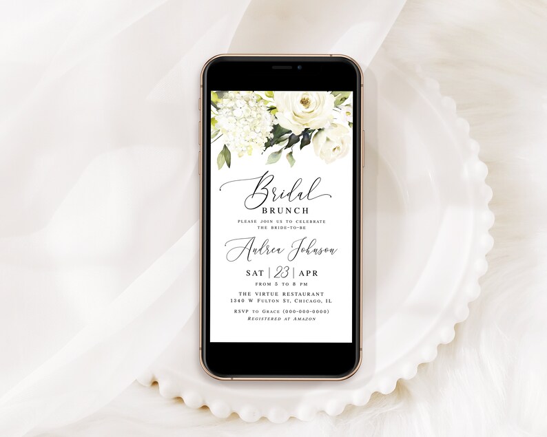 Pode incluir: Uma maquete de tela de telefone com um design floral branco e verde com um convite para um brunch de casamento. O convite diz "Bridal Brunch" e inclui o nome da noiva, "Andrea Johnson", a data "Sat | 23 | Apr", a hora "From 5 to 8 PM", o local "The Virtue Restaurant", o endere&ccedil;o "1340 W Fulton St, Chicago, IL", o n&uacute;mero de RSVP "(800) 300-0000" e as informa&ccedil;&otilde;es de registro "Registered at Amazon".