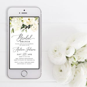 Pode incluir: Uma tela de smartphone branca exibindo um convite para um brunch de casamento com um design floral. O convite inclui o texto "Bridal Brunch", "Please join us to celebrate the bride-to-be", "Audrey Johnson", "Sat | 23 | Apr", "From 5 to 8 PM", "The Virtue Restaurant", "1340 W Fulton St. Chicago, IL", "RSVP to Grace (000-000-0000)" e "Registered at Amazon".