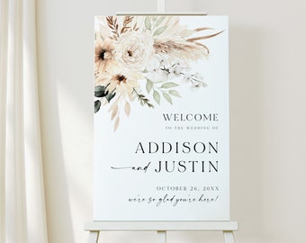 May include: A wedding welcome sign with a floral design in shades of beige, brown, and green. The sign reads "Welcome to the wedding of Addison and Justin, October 26, 20XX, we're so glad you're here!"