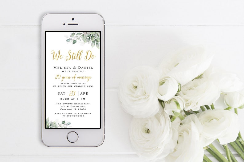 May include: A smartphone screen displaying a wedding anniversary invitation with green foliage and gold text. The invitation reads "We Still Do" and includes the couple's names, the date, time, and location of the event.