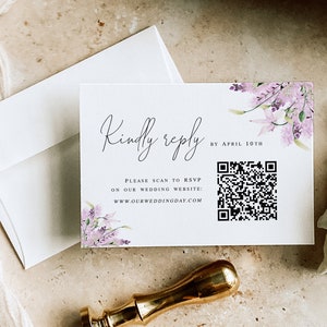 May include: A white RSVP card with a floral design and a QR code. The text on the card reads "Kindly reply by April 10th. Please scan to RSVP on our wedding website: www.ourweddingday.com"