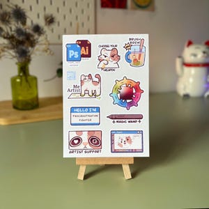 Peut inclure: Un ensemble de neuf autocollants sur le thème du chat pour les artistes. Les autocollants comprennent un chat tenant un pinceau, un chat avec une roue chromatique, un chat avec une baguette magique, un chat avec une tasse de café et un chat avec un écran d'ordinateur. Les autocollants sont imprimés sur du papier blanc avec une finition brillante.