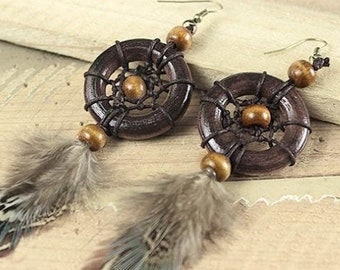 May include: A pair of brown wooden dreamcatcher earrings with brown feathers and brown beads.