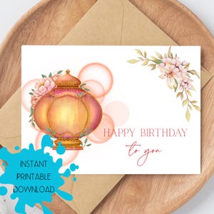 Könnte beinhalten: Geburtstagskarte mit einer Illustration einer rosa-goldenen Laterne, verziert mit floralen Elementen. Der Text "Happy Birthday to you" ist in eleganter Schrift geschrieben, mit dem Text "Instant Printable Download".