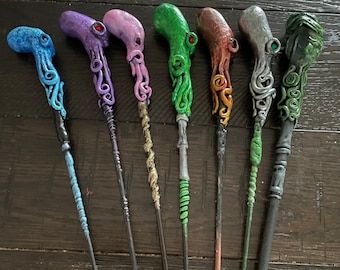 May include: Seven colorful wands with octopus-like details. The wands are made of a textured material and have a variety of colors, including blue, purple, pink, green, orange, gray, and green.