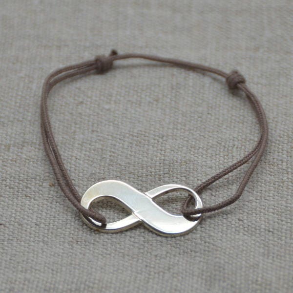 Bracelet infini Argent ou Plaqué Or sur lien coton ajustable.