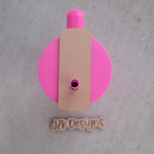 May include: A pink tumbler with a brown paper straw holder and a wooden sign that says "JZK Designs".
