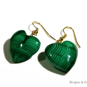 May include: A pair of green malachite heart-shaped earrings with gold hooks.
