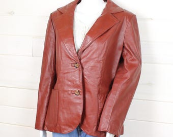 May include: A brown leather blazer with a single-breasted closure and two front pockets.