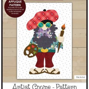 May include: An applique pattern featuring an artist gnome design. The gnome wears a red plaid beret, round glasses, and holds a paintbrush and palette. The finished size is 7" x 11".