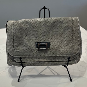 May include: A gray snakeskin-textured clutch purse with a silver clasp.