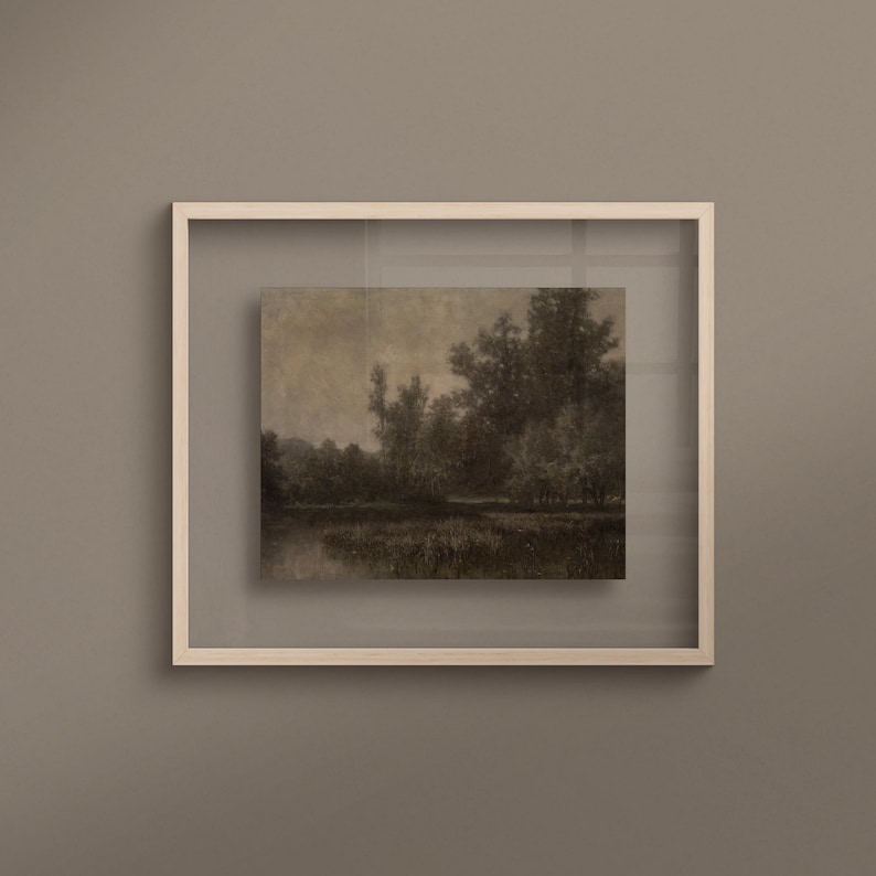 May include: A framed landscape art print in sepia tones, depicting trees and water. The artwork is presented within a white, square frame, offering a minimalist design. The print conveys a sense of peace and natural beauty, suitable for various interior styles.