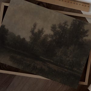 May include: A sepia-toned landscape print depicting trees and water in a dark, atmospheric scene. The artwork is framed in a light wooden frame, with a ruler visible. The vintage aesthetic creates a tranquil mood. The print is reminiscent of a classic painting.