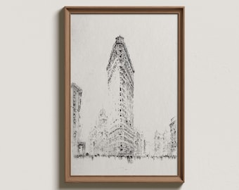 Puede incluir: Boceto en blanco y negro del edificio Flatiron en la ciudad de Nueva York, enmarcado en un marco de madera marrón claro. La obra de arte representa el icónico rascacielos triangular y los edificios circundantes. Las palabras "WALL DECO PRINT SHOP" están impresas en la parte inferior.