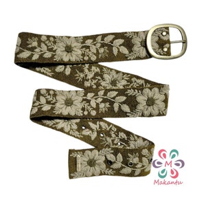 May include: A green woven belt with a silver buckle and white embroidered flowers.