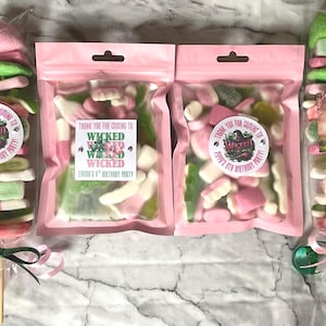 May include: Pink and green candy skewers with a thank you for coming to [name]'s 8th birthday party label. The sweets are in clear plastic bags with a pink background. The bags are tied with a green ribbon.