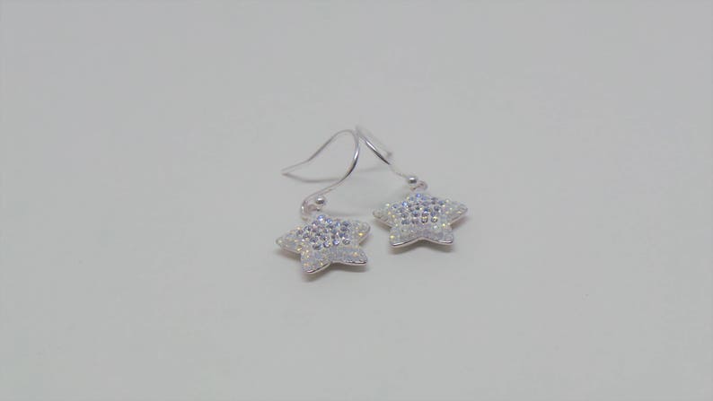 Sterling silver hook earrings featuring Swarovski star pandant. image 1