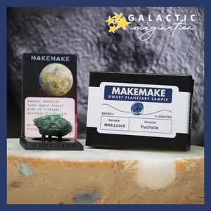 Puede incluir: Una exhibición que presenta una muestra de planeta enano etiquetada como "Makemake". La exhibición incluye una pequeña muestra de mineral verde, una tarjeta con detalles y una caja con el texto "Makemake Dwarf Planetary Sample". El fondo tiene el texto "Galactic Imagination".