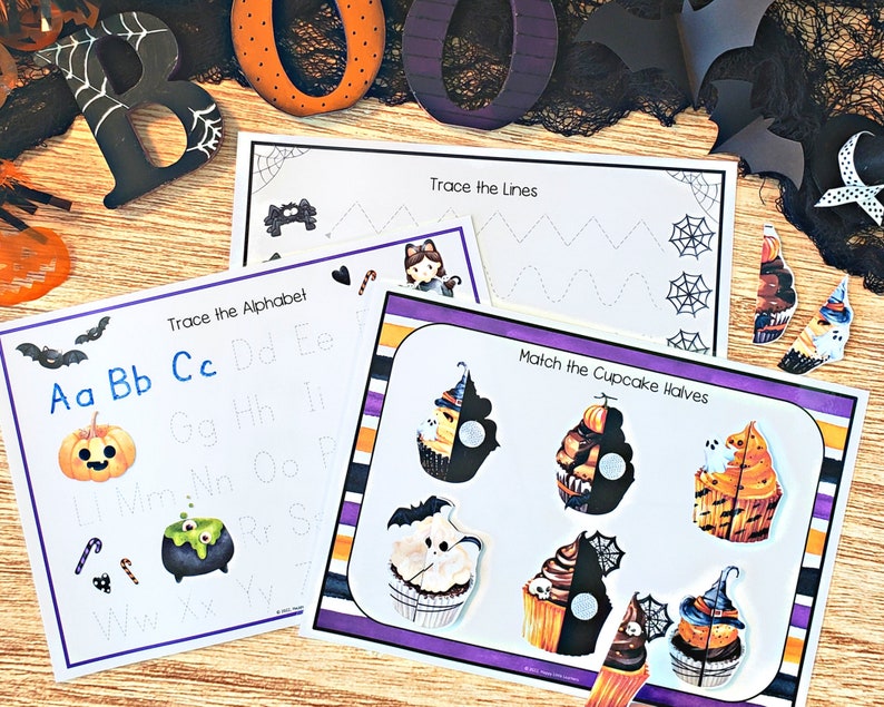 May include: Three printable Halloween-themed educational worksheets for kids. The first worksheet features the alphabet with a pumpkin, a cauldron, and candy canes. The second worksheet has lines to trace. The third worksheet has cupcake halves to match.