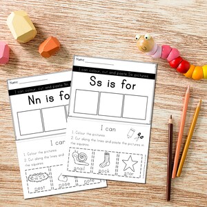 May include: Two printable worksheets for kids to learn the letters N and S. Each worksheet has a title, "Nn is for" and "Ss is for", with three blank boxes for pictures. Below the boxes, there are instructions to color, cut, and paste pictures. The instructions include a list of words that start with the letter, such as "nest", "nose", "note" for the letter N and "snail", "sock", "star" for the letter S.