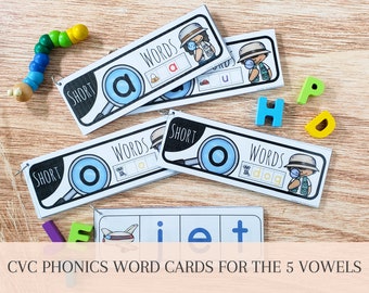 May include: A set of five CVC phonics word cards for teaching short vowel sounds. Each card features a magnifying glass with a vowel, the word "short", and a picture of a word with the short vowel sound. The words are "at", "up", "og", "it", and "dog".