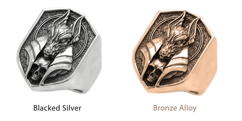 May include: A silver ring with a wolf head design and a skull. The ring is also available in a bronze alloy.