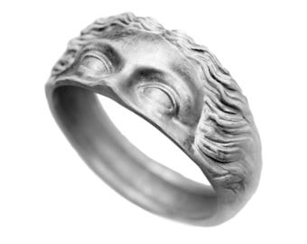 Könnte beinhalten: Ein silberner Ring mit einer detaillierten Gesichtsskulptur. Das Gesicht hat geschlossene Augen und eine strukturierte Frisur.