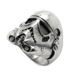 Pode incluir: Um anel de prata com um design tridimensional detalhado de um capacete de Stormtrooper.