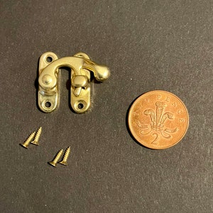 以下が含まれることがあります： レバーハンドルと2本のネジが付いた金色の金属製ラッチ。ラッチは2ペンス硬貨と同じくらいの大きさです。