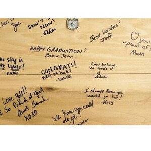 K&ouml;nnte beinhalten: Ein Holzschild mit handgeschriebenen Gl&uuml;ckw&uuml;nschen und guten W&uuml;nschen. Das Schild enth&auml;lt den Text "Happy Graduation", "Congrats", "Best of Luck", "Love you", "Proud of you", "The sky is the limit", "Best Wishes", "Can't believe we made it", "I always knew you would go far", "We knew you could do it", "You proud of you".