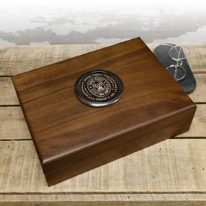 May include: A wooden box with a silver metal plaque featuring the Eagle Scout emblem and the text "Eagle Scout Scouting America" and "Michael Schmitz February 21, 2023".