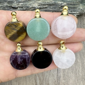 Könnte beinhalten: Sechs runde Edelstein-Flaschenverschlüsse mit goldenen Kappen. Die Steine sind Amethyst, Schwarz, klarer Quarz, grüner Aventurin, Tigerauge und Rosenquarz.