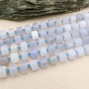 May include: A strand of light blue and white gemstone beads. The beads are faceted and have a polished finish. The beads are strung on a clear thread.