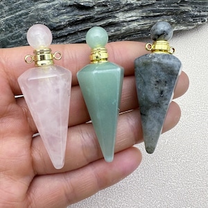 May include: Three crystal point bottle stoppers with gold caps. The stoppers are made of rose quartz, green aventurine, and grey labradorite.