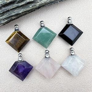 Puede incluir: Seis botellas de cristal cuadradas con tapones plateados. Las botellas son de color amatista, cuarzo rosa, cuarzo transparente, aventurina verde, ojo de tigre y obsidiana negra.