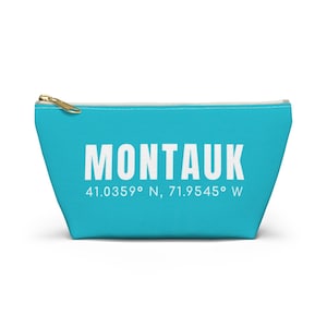 May include: A turquoise blue zippered pouch with the text "Montauk" in white and the coordinates "41.0359° N, 71.9545° W" in white.