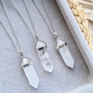 May include: Three silver necklaces with clear quartz crystal point pendants. Each pendant is set in a silver bezel.