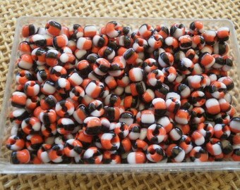 Box of 22 grams of seed beads, size 4 mm, striped orange, white and black colors