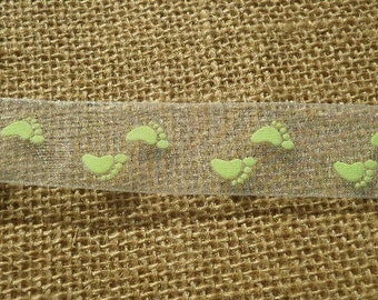 Deux mètres de ruban organza en  polyester  , coloris blanc , motifs "pieds de bébés" vert , largeur 22 mm