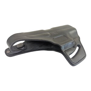 May include: A black leather holster with a molded design. The holster features a belt loop with a snap closure and a cutout for a firearm. The overall design is sleek and functional, suitable for concealed carry.
