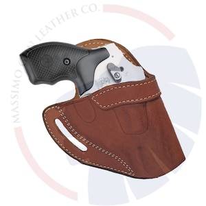 May include: A brown leather holster with a silver revolver inside. The holster has a stitched design and a cut-out for the trigger guard. The revolver has a black grip and a silver barrel.